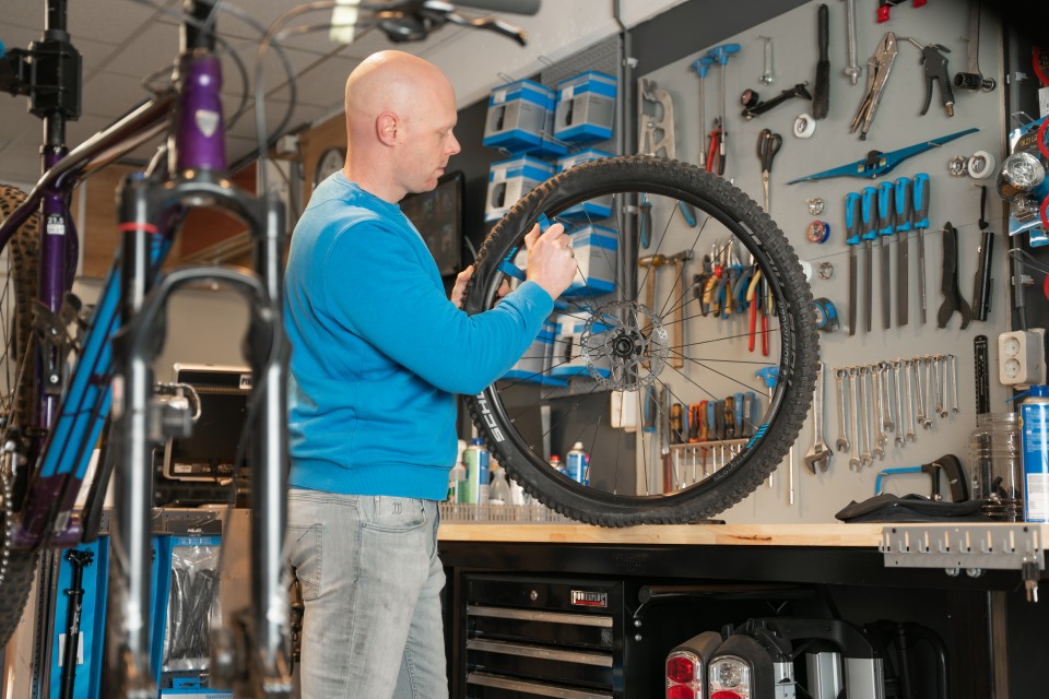 Jan houdt een wiel vast bij de gereedschapswand